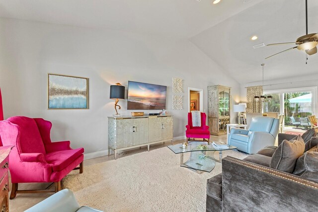 living room with tile patterned flooring, ceiling fan with notable chandelier, and high vaulted ceiling