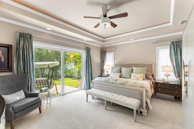 carpeted bedroom with access to outside, ceiling fan, and a raised ceiling