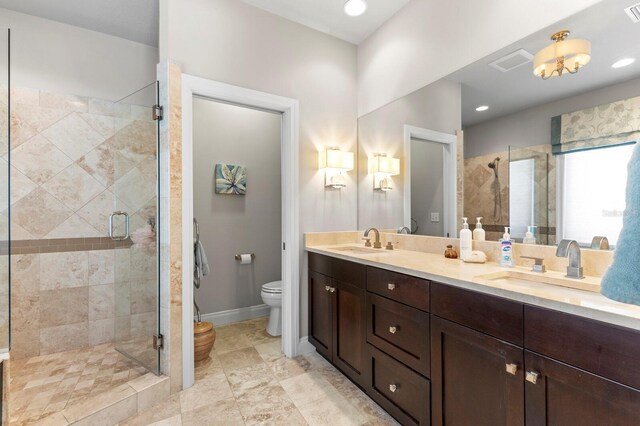 bathroom with toilet, a shower with door, tile patterned flooring, and dual bowl vanity