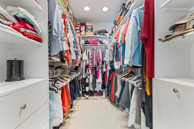 walk in closet with light colored carpet