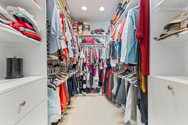 walk in closet with light carpet