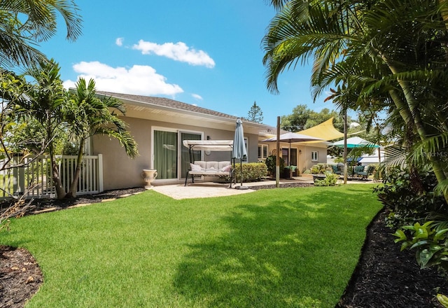 back of property with a lawn and a patio