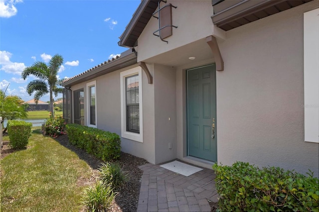 property entrance featuring a lawn