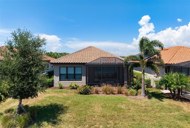 back of house with a lanai and a lawn