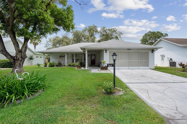 ranch-style home with a garage, cooling unit, and a front yard