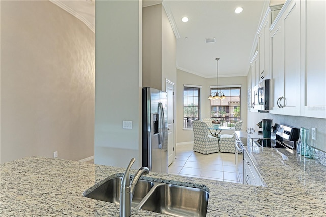 kitchen featuring light tile patterned floors, appliances with stainless steel finishes, light stone countertops, sink, and white cabinetry