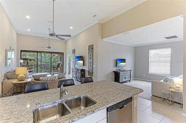 kitchen featuring light tile patterned flooring, stainless steel dishwasher, light stone countertops, ceiling fan, and sink