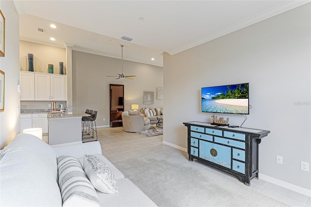 living room with ceiling fan, light colored carpet, and ornamental molding