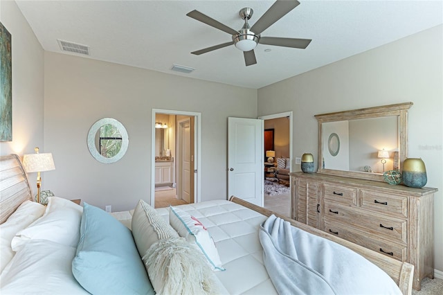 bedroom with ceiling fan, ensuite bath, and light carpet