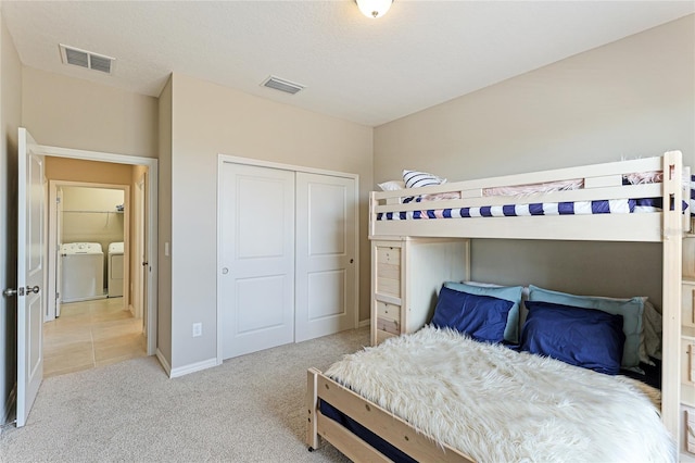 carpeted bedroom featuring a closet and separate washer and dryer