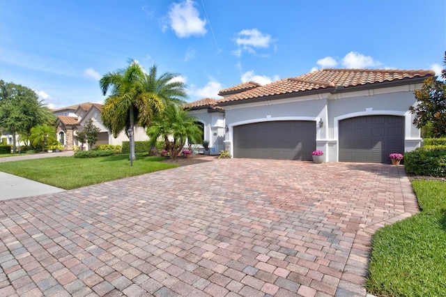 mediterranean / spanish home with a garage and a front lawn