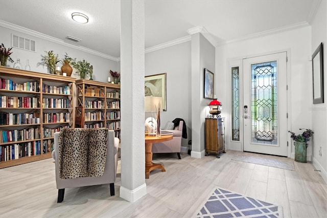 foyer with crown molding, a textured ceiling, and light hardwood / wood-style flooring