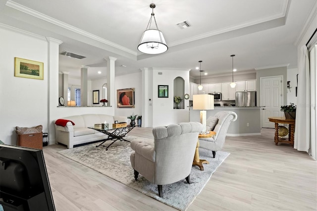 living room featuring light wood-type flooring, ornate columns, and ornamental molding