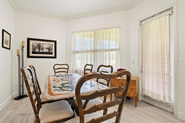 dining room with crown molding and light wood-type flooring