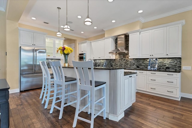 kitchen with appliances with stainless steel finishes, backsplash, wall chimney range hood, and dark hardwood / wood-style floors