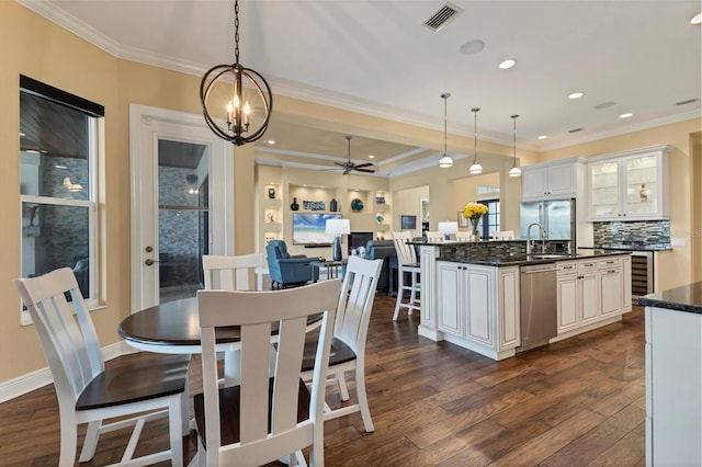 interior space with dark stone countertops, dark wood-type flooring, stainless steel appliances, and crown molding