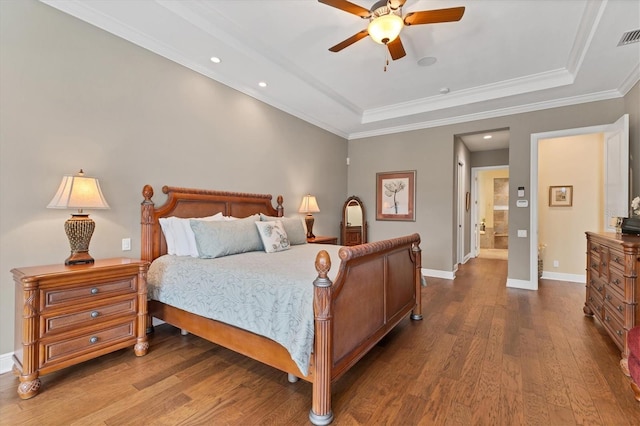 bedroom with ceiling fan, ornamental molding, hardwood / wood-style flooring, connected bathroom, and a tray ceiling