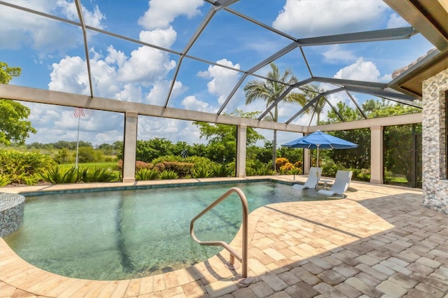 view of pool with glass enclosure and a patio