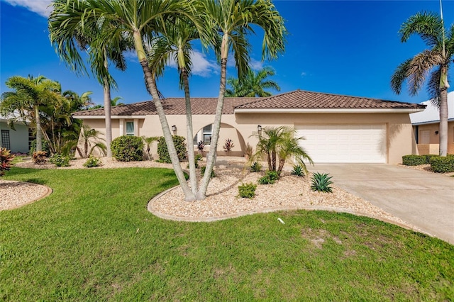 view of front of home with a garage, concrete driveway, stucco siding, a tiled roof, and a front yard