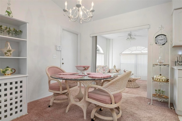 carpeted dining area featuring ceiling fan with notable chandelier