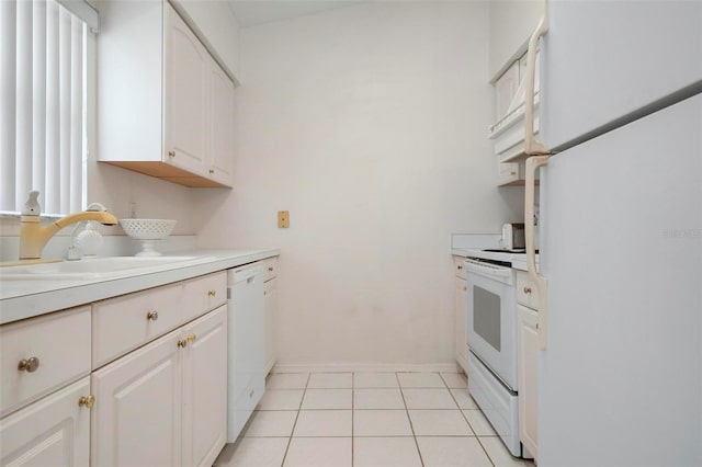 kitchen featuring light tile patterned floors, white cabinets, white appliances, and sink