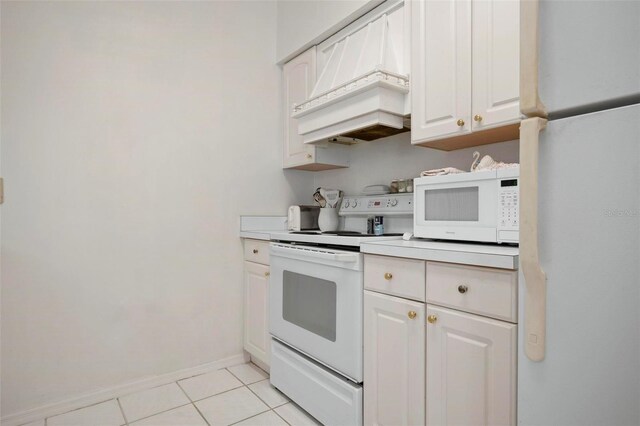 kitchen with white cabinets, white appliances, light tile patterned floors, and premium range hood