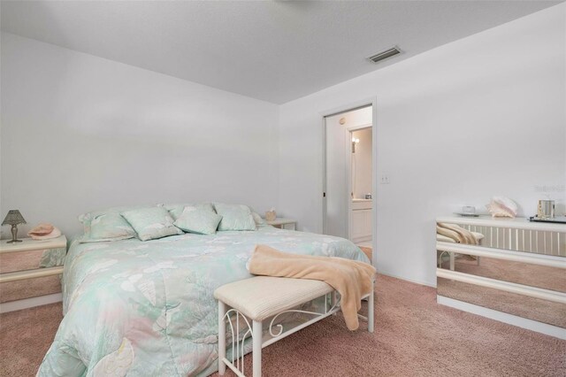 carpeted bedroom with ensuite bath