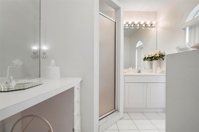 bathroom featuring a shower with shower door, vanity, and tile patterned floors