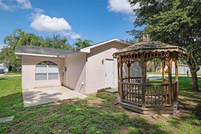 rear view of house featuring a patio area, a gazebo, and a yard