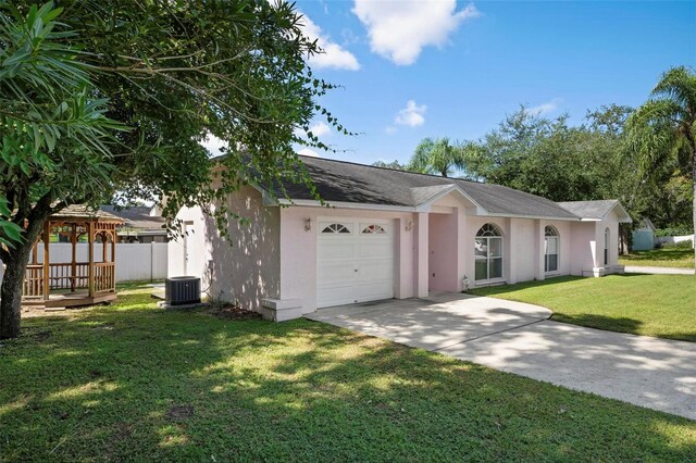 ranch-style home with a front yard, central AC unit, and a garage