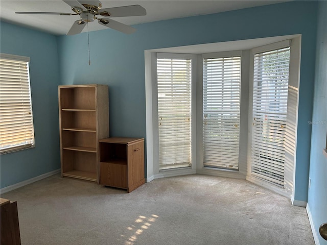 interior space with ceiling fan and light carpet