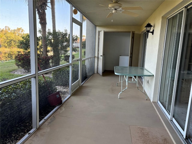 unfurnished sunroom featuring ceiling fan