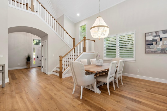 dining area featuring a healthy amount of sunlight, light hardwood / wood-style floors, and high vaulted ceiling