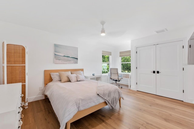 bedroom featuring ceiling fan, light wood-type flooring, and a closet