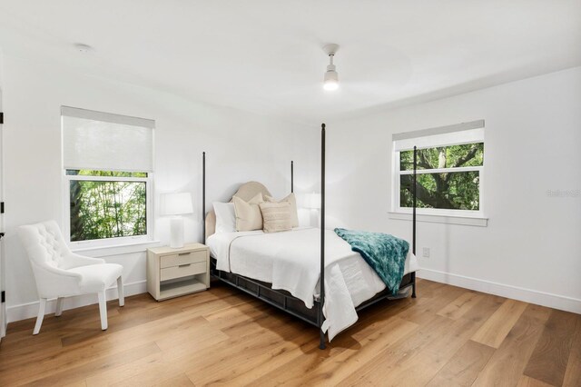 bedroom with multiple windows and light hardwood / wood-style floors