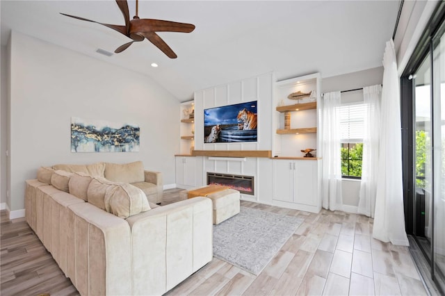 living room featuring ceiling fan, light hardwood / wood-style flooring, and vaulted ceiling