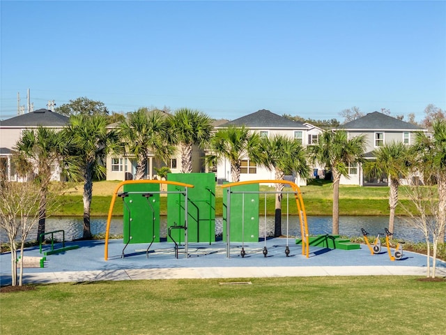 view of playground featuring a lawn and a water view