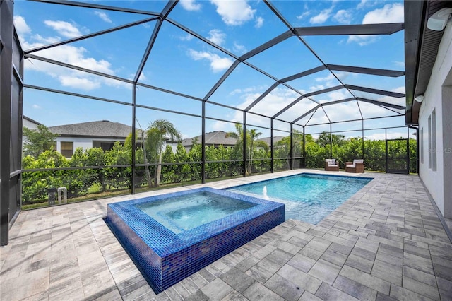 view of pool featuring an in ground hot tub, glass enclosure, and a patio area