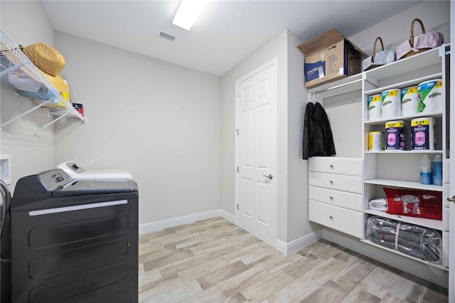 washroom with light hardwood / wood-style flooring and washing machine and clothes dryer