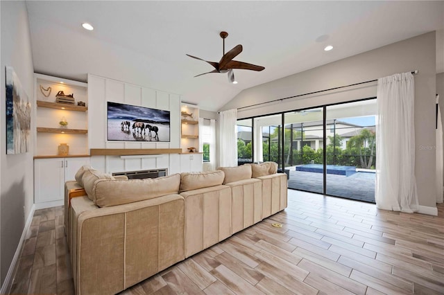 living room with lofted ceiling, ceiling fan, and light hardwood / wood-style flooring