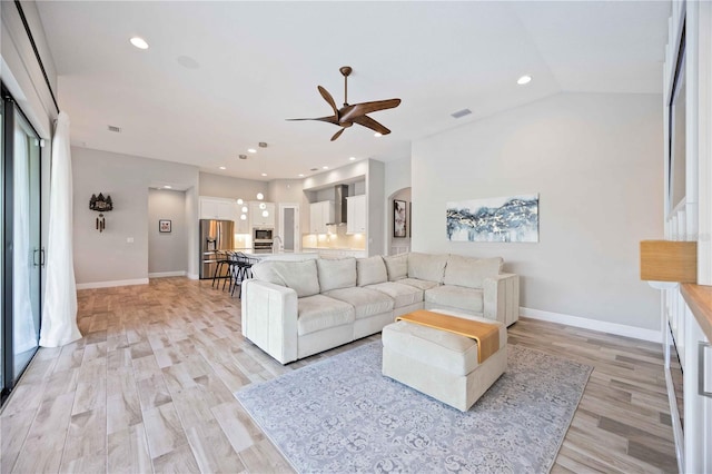 living room featuring ceiling fan, light hardwood / wood-style flooring, and lofted ceiling