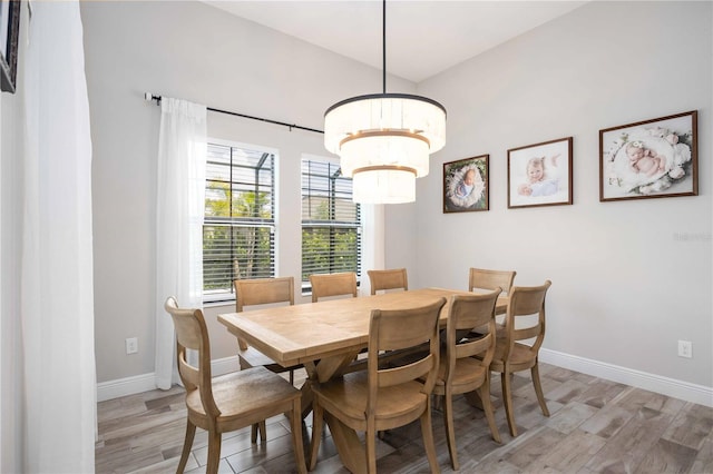 dining area featuring an inviting chandelier and light hardwood / wood-style flooring