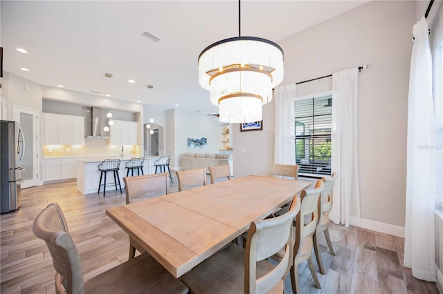 dining area featuring light hardwood / wood-style floors and a chandelier