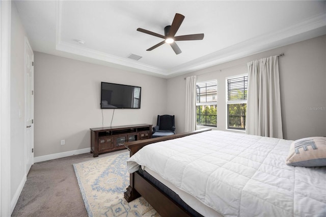 carpeted bedroom featuring a tray ceiling and ceiling fan