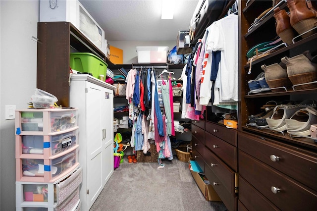 walk in closet featuring light colored carpet