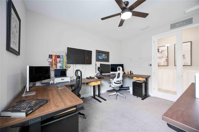 carpeted home office featuring ceiling fan