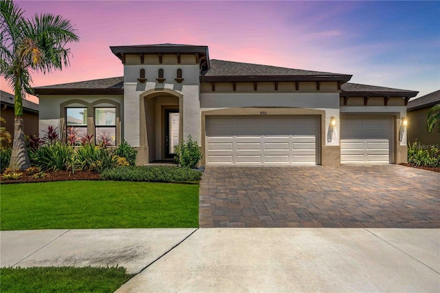 view of front of house featuring a garage and a lawn