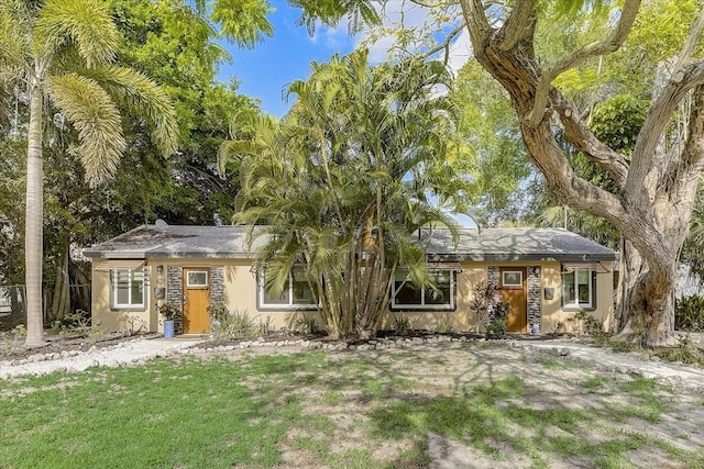 ranch-style house with stucco siding and a front lawn