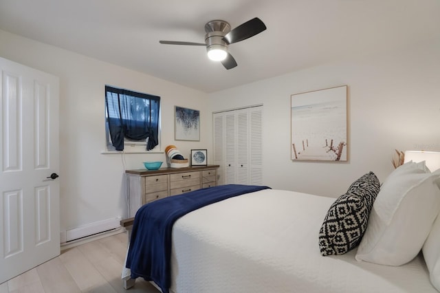 bedroom with a ceiling fan, baseboards, a closet, and baseboard heating