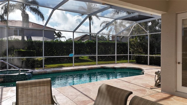 view of pool with a patio, an in ground hot tub, and glass enclosure